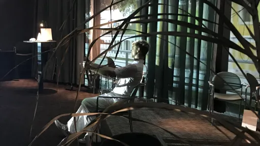 Becky holding a steering wheel in front of a projection screen